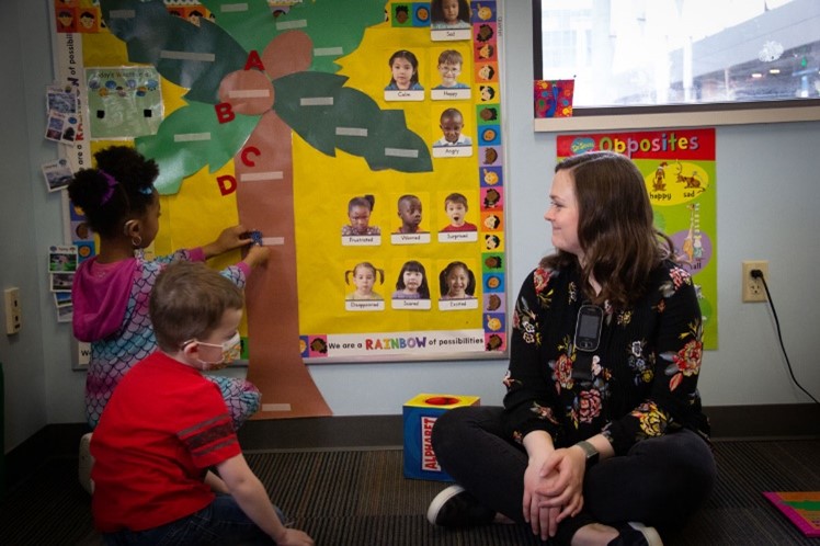 child playing next to instructor